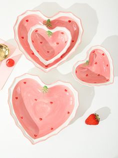 three heart shaped plates with strawberries on them