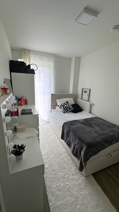 a bedroom with a bed, nightstands and other items on the floor in front of a window