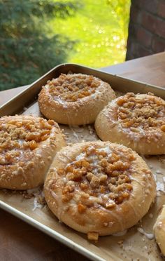 four pastries sitting on top of a pan covered in icing