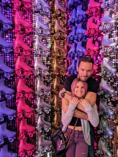 a man and woman standing in front of colorful wall