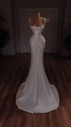 a white wedding dress on display in a room