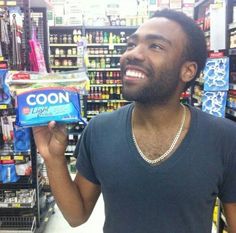 a man holding up a box of toothpaste in a store