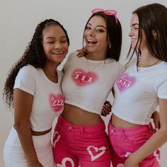 three girls in pink pants and white shirts posing for the camera with their hands on their hips