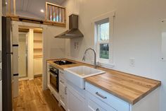 a kitchen with white cabinets and wooden counter tops