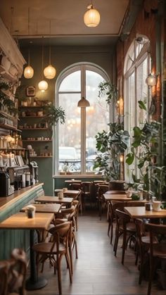 the interior of a restaurant with tables, chairs and potted plants on the windowsill