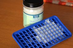 a jar of virgin coconut oil next to a plastic ice tray on a wooden table