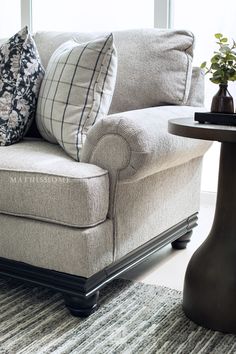 a living room with a couch, table and window in the backround area