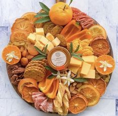 a platter filled with oranges, cheese and crackers