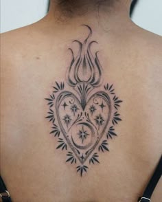 the back of a woman's neck with a heart tattoo on it and stars