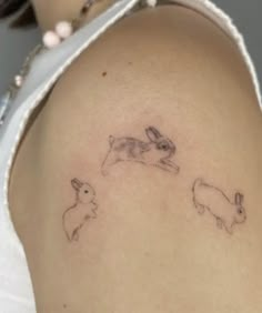 a woman with a tattoo on her stomach has two rabbits running in the same direction