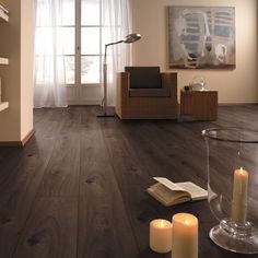 a living room filled with furniture and a book shelf on top of a hard wood floor