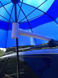 an open blue umbrella sitting on top of a car