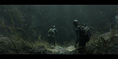 two men walking through a cave in the woods with backpacks on their back and one man wearing a camouflage jacket