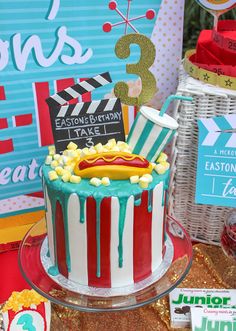 a birthday cake with hot dog and movie claps on it