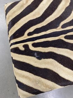 a zebra print area rug on top of a metal table with a black and white stripe pattern