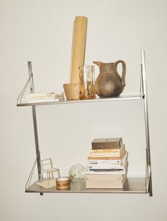 two metal shelves with books and vases on them