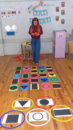 a woman standing on top of a wooden floor next to an array of circles and squares