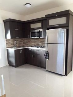 an empty kitchen with stainless steel appliances and brown cabinetry is pictured in this image