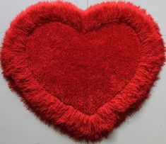 a red heart shaped rug hanging on the wall