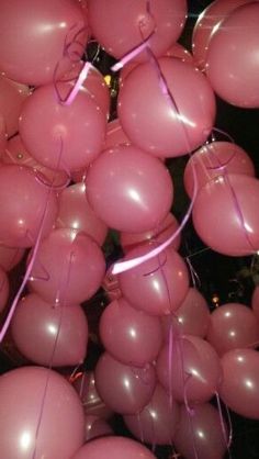 a bunch of pink balloons are hanging from the ceiling