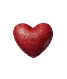 a red leather heart shaped object with the word yes printed on it's side