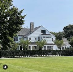 a large white house sitting on top of a lush green field