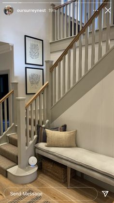 a black and white cat laying on top of a bench next to a stair case