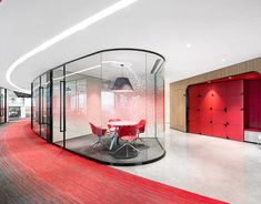 an office with glass walls and red carpeted flooring on the wall is shown