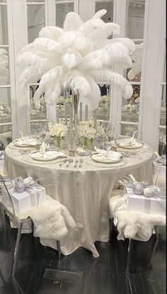 the table is set with white flowers and place settings