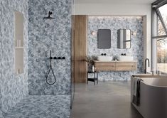 a modern bathroom with blue and white wallpaper, large tub, sink and shower