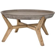 a concrete table with wooden legs and a round tray on the top that has been turned into a coffee table