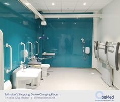 a blue and white bathroom with two sinks, toilet paper dispensers and shower stalls