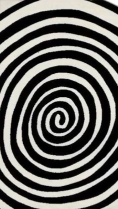 a black and white rug with an abstract design in the shape of a spiral on it