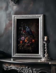 a painting is hanging on the wall next to a table with candles and a candle holder