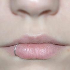 a close up view of a woman's lips with a ring on her lip