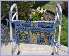 an ironing board with flowers on it and blue trim around the handles is sitting outside