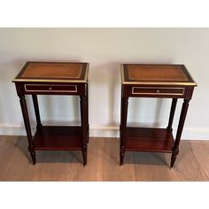 two small wooden tables sitting next to each other on top of a hard wood floor