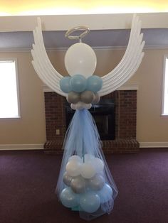 balloon arch with blue and white balloons hanging from it's sides in a living room