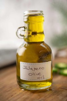 a bottle of olive oil sitting on top of a wooden table