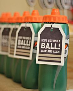 four green sports bottles with tags on them sitting on a table next to each other