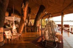 the inside of a tent with chairs, tables and other items in it at night