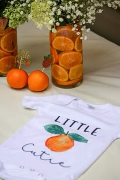 three jars filled with oranges and baby's breath onesuits on top of a table