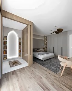 a bedroom with a bed, desk and chair in it next to a book shelf