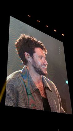 a man that is standing up in front of a screen with his face close to the camera