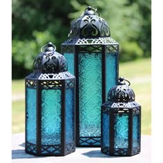 three blue lanterns sitting on top of a table