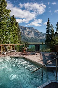 a hot tub sitting on top of a wooden deck next to a forest filled with trees