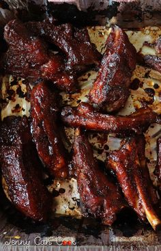 barbecued ribs and onions in a tin foil container with seasoning sprinkled on top