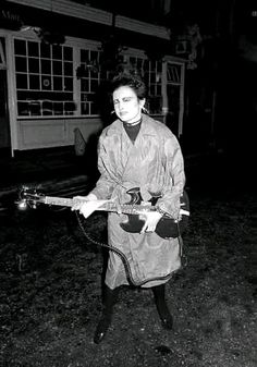 black and white photograph of woman holding an electric guitar