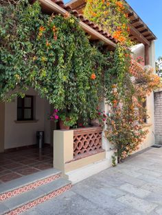 an outdoor area with flowers and plants growing on the side of the building, next to steps that lead up to it