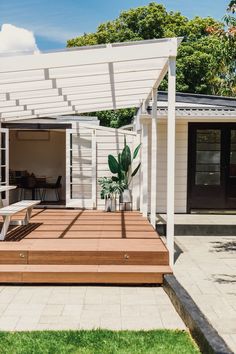 an outdoor patio with wooden steps and white pergola